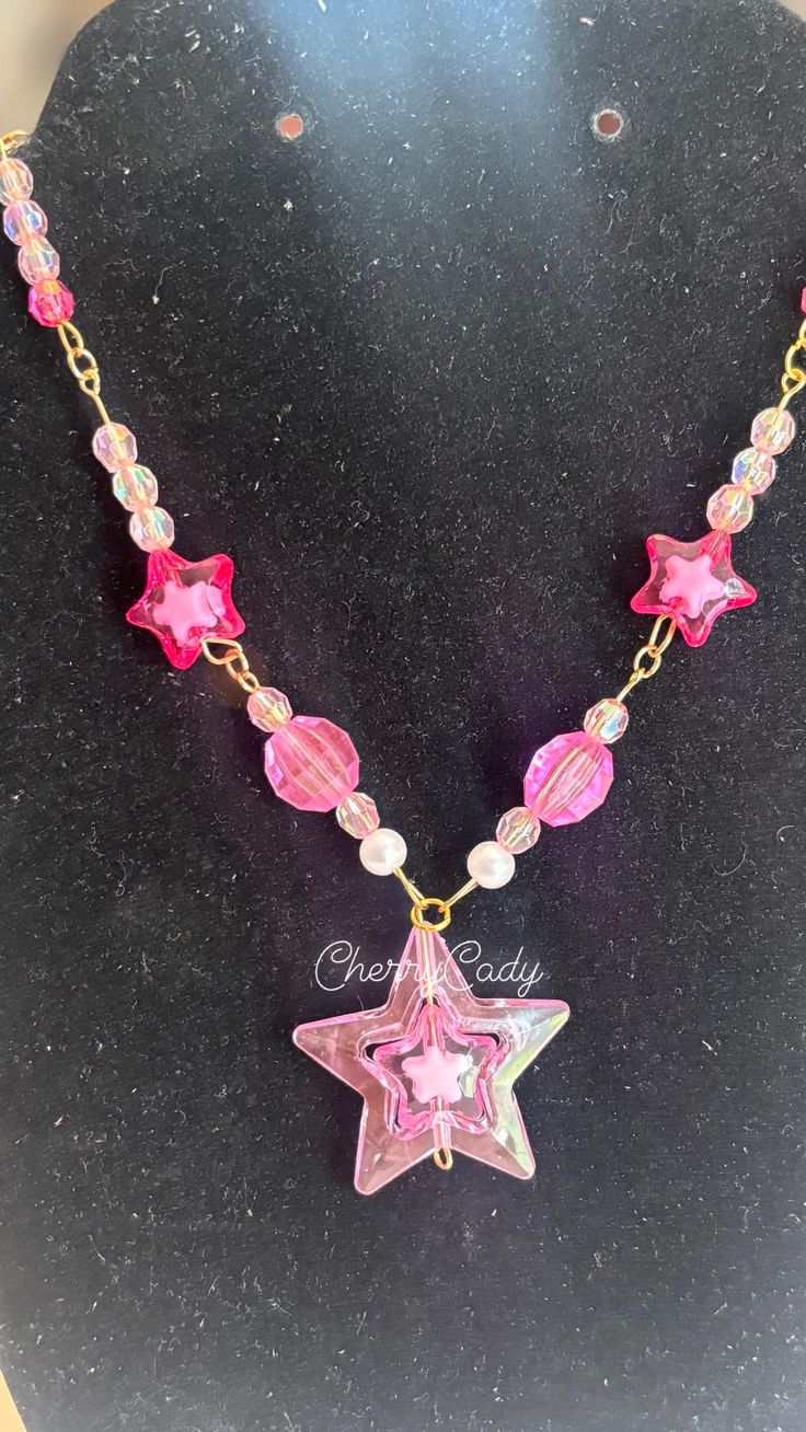 A handmade charm necklace that makes a perfect star-powered statement piece! The necklace is perfect for any concert, outing, or everyday wear! Necklace is 11 inches length wise! Party Star Charm Necklaces, Party Necklaces With Star Charm, Party Necklace With Star Charm, Trendy Pink Necklace With Star Charm, Trendy Star Charm Necklaces, Star Charm Necklace For Festivals, Handmade Star Necklaces For Party, Trendy Handmade Star-shaped Necklaces, Trendy Handmade Star-shaped Necklace