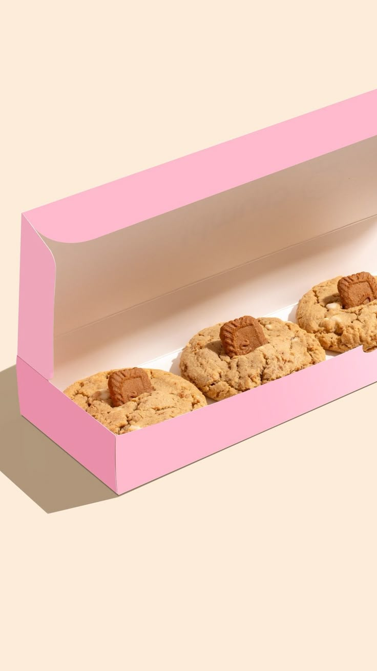 three cookies in a pink box on a beige background