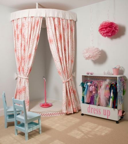 a child's bedroom decorated in pink and white with drapes on the windows