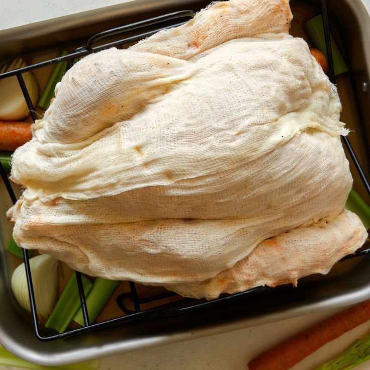 a metal container filled with raw chicken and vegetables