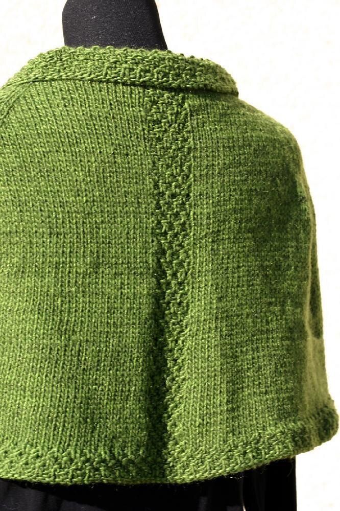 a close up of a green shawl on a mannequin