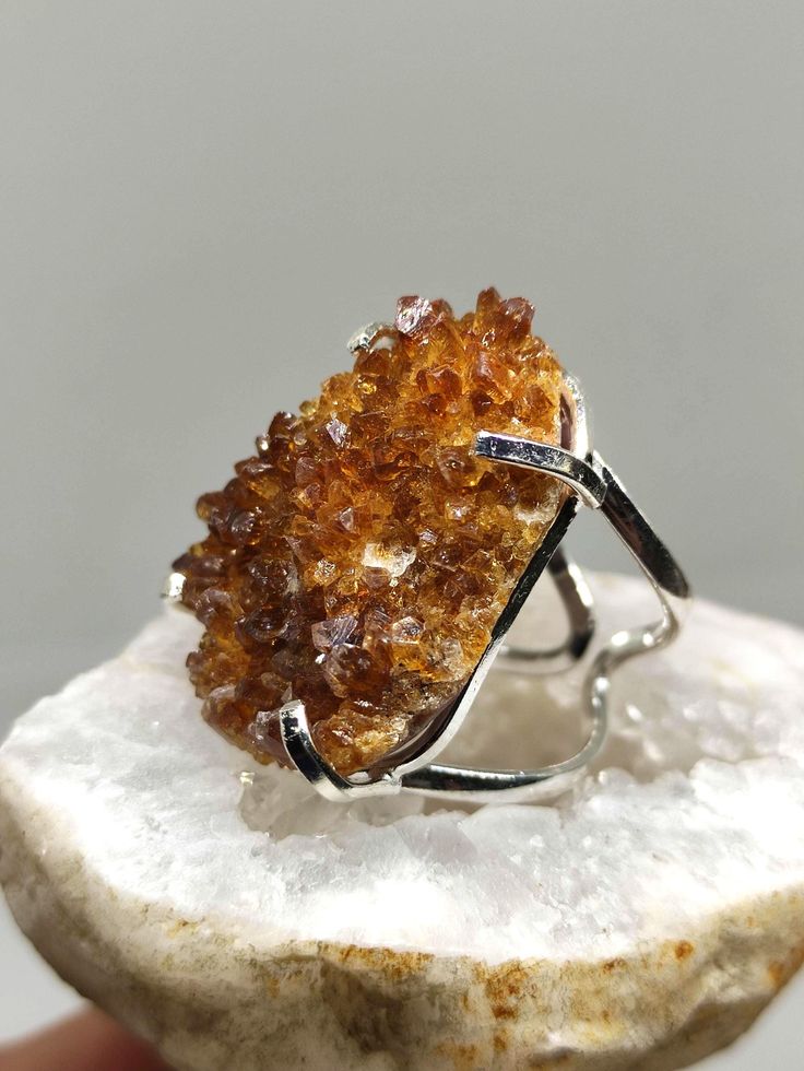 Make a Bold Statement with our Raw Citrine Ring! Elevate your style and showcase your unique personality with our exceptional Raw Citrine Ring. Crafted with a genuine, uncut citrine gemstone, this ring embodies the raw beauty of nature. The adjustable band ensures a perfect fit for any finger, providing both comfort and versatility. Made with sterling silver filled metal, this ring offers durability and a lustrous shine that complements the radiant citrine stone. Citrine is revered for its abili Spiritual Citrine Gemstone Rings, Amber Crystal Promise Ring, Citrine Gemstone Crystal Promise Ring, Adjustable Citrine Gemstone Rings, Citrine Crystal Promise Ring With Gemstone, Spiritual Amber Citrine Rings, Spiritual Citrine Ring Jewelry, Citrine Stone Ring Jewelry, Citrine Ring With Large Stone