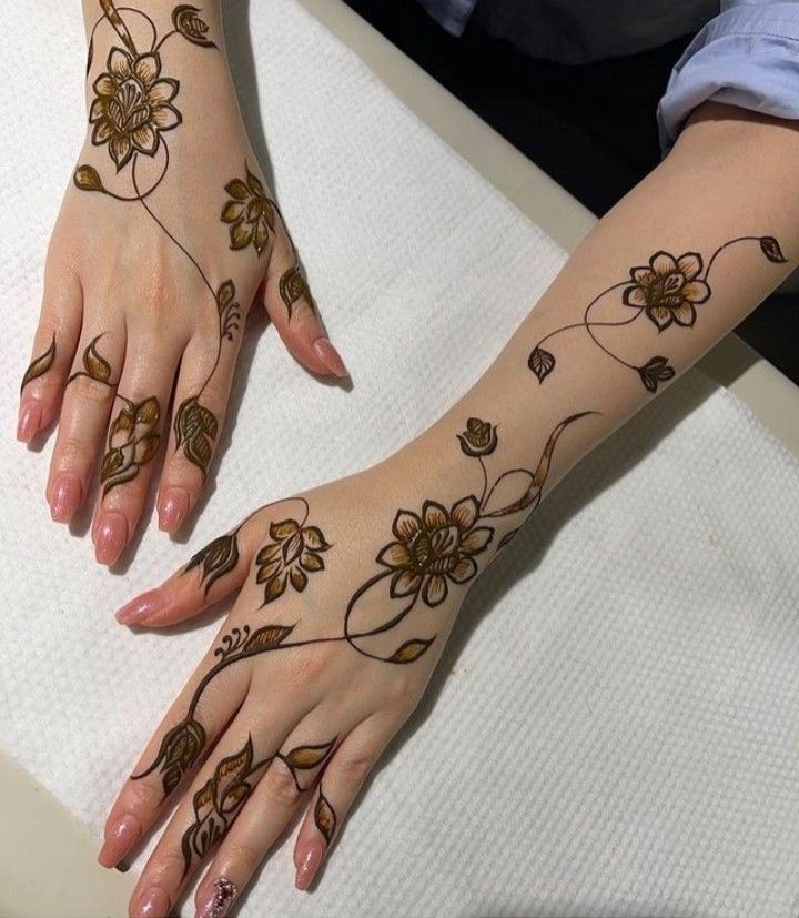 two hands with henna tattoos on them