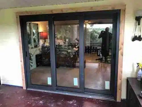 the inside of a house with sliding glass doors on both sides and a man standing in the doorway