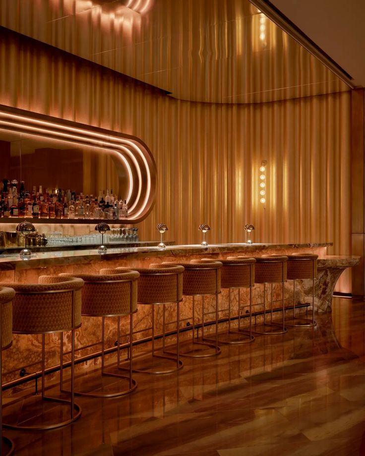 a dimly lit bar with stools next to it