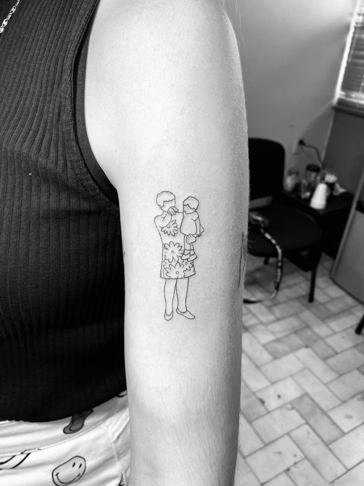 a black and white photo of a woman's arm with a tattoo on it