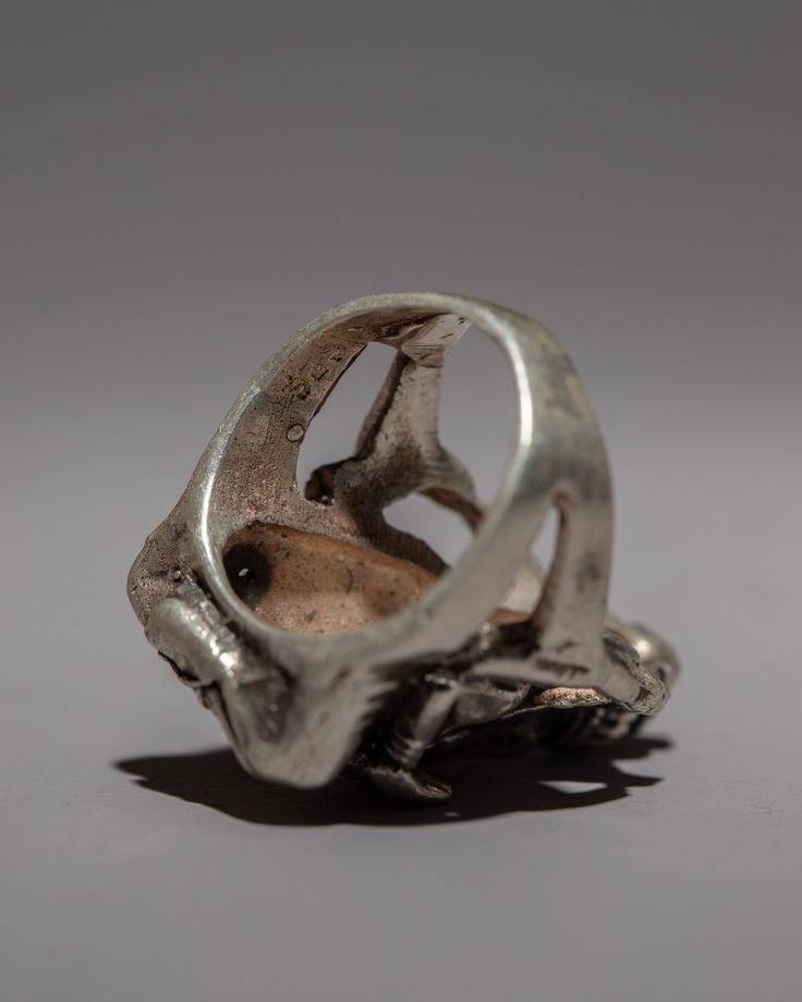 an old silver object sitting on top of a table