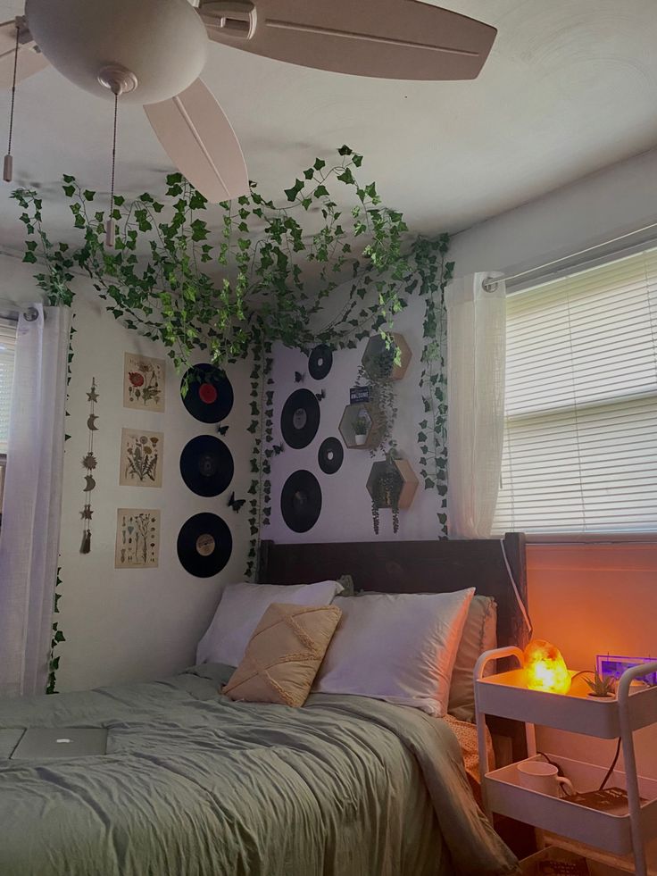 a bedroom with plants growing on the wall above the bed and ceiling fan hanging from the ceiling