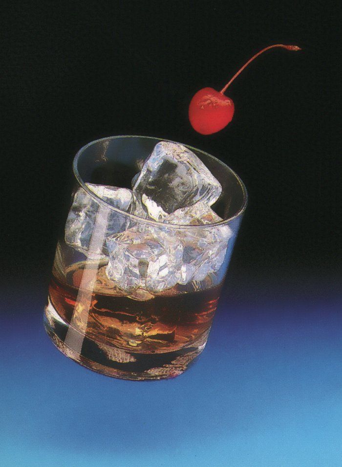 a glass filled with ice and a cherry on the rim, sitting on a blue surface