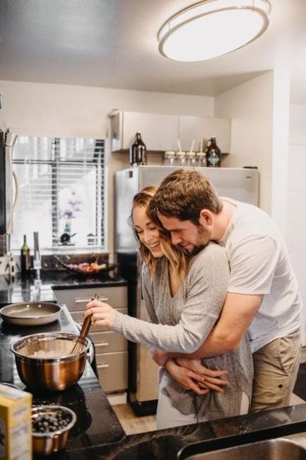 a man and woman are cooking in the kitchen