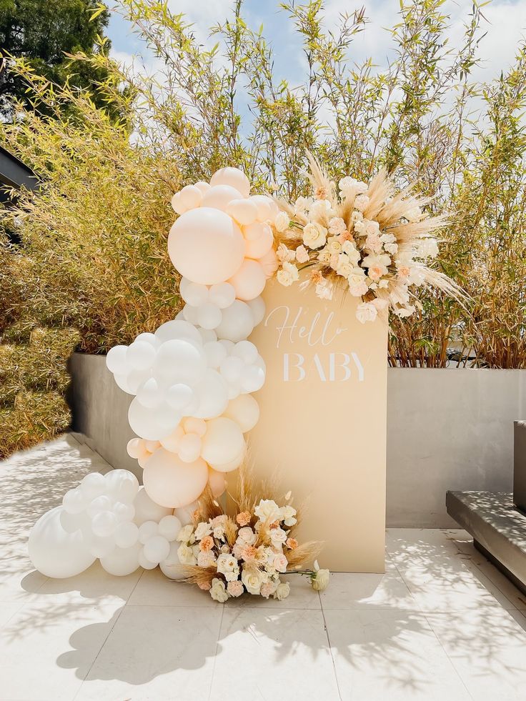 balloons and flowers decorate the entrance to a baby shower