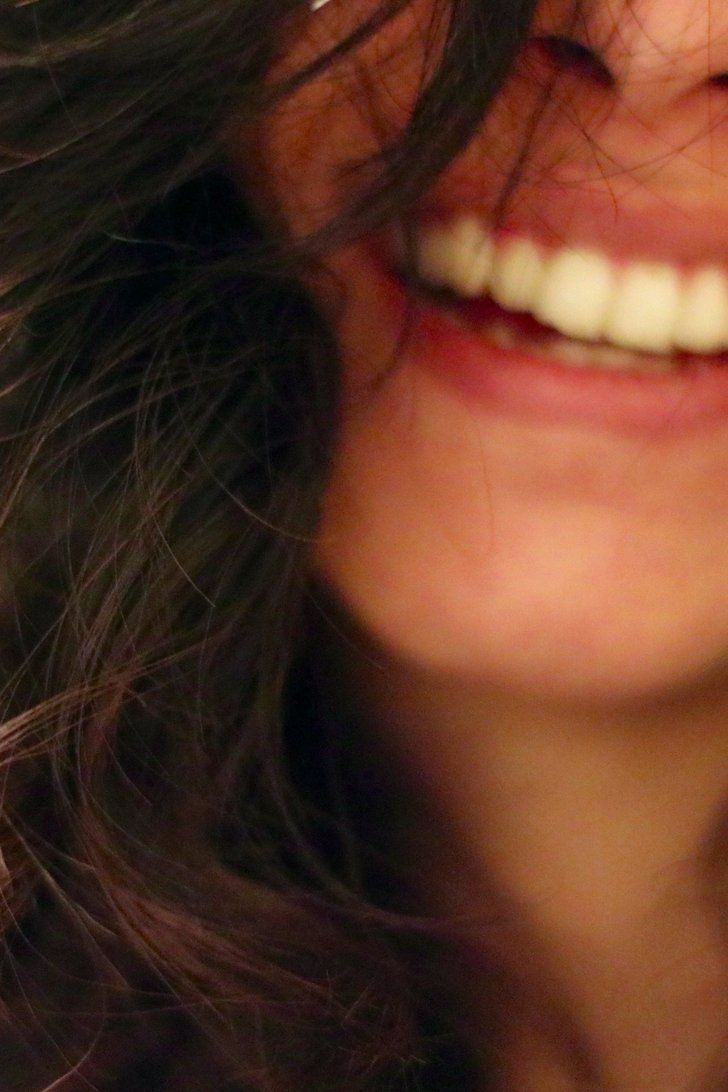 a close up of a woman's face with her hair blowing in the wind