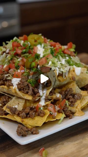 nachos with meat and vegetables on a white plate