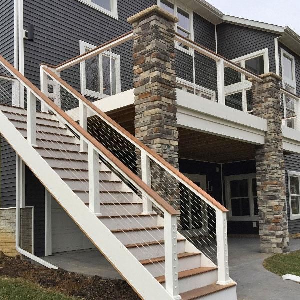 a house with stone and wood stairs leading up to the front door