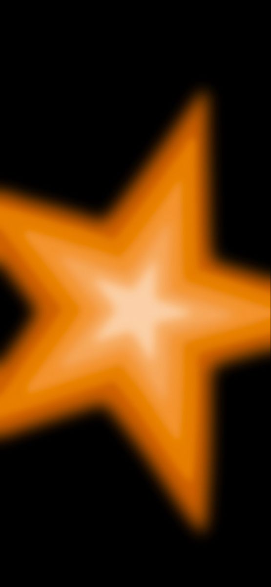 an orange and white star on a black background with the light reflecting off it's side