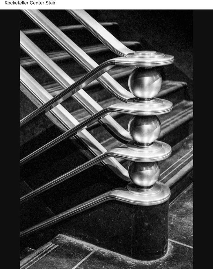 black and white photograph of an escalator with four balls on the bottom one