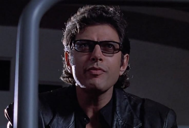 a man wearing glasses and a leather jacket