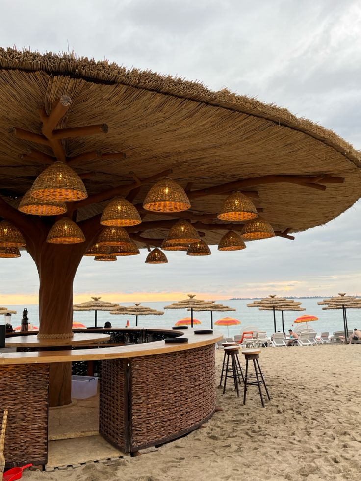 an outdoor bar on the beach with umbrellas