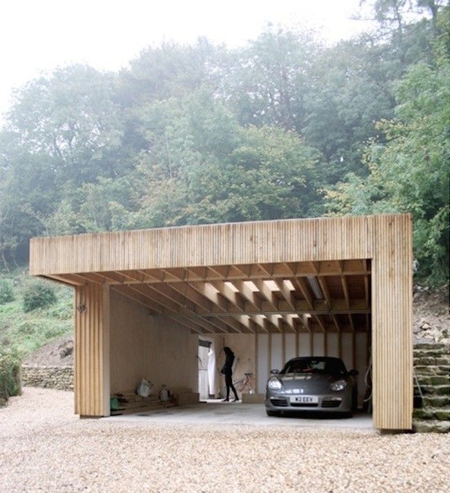 a car is parked in front of a wooden structure with stairs leading up to it