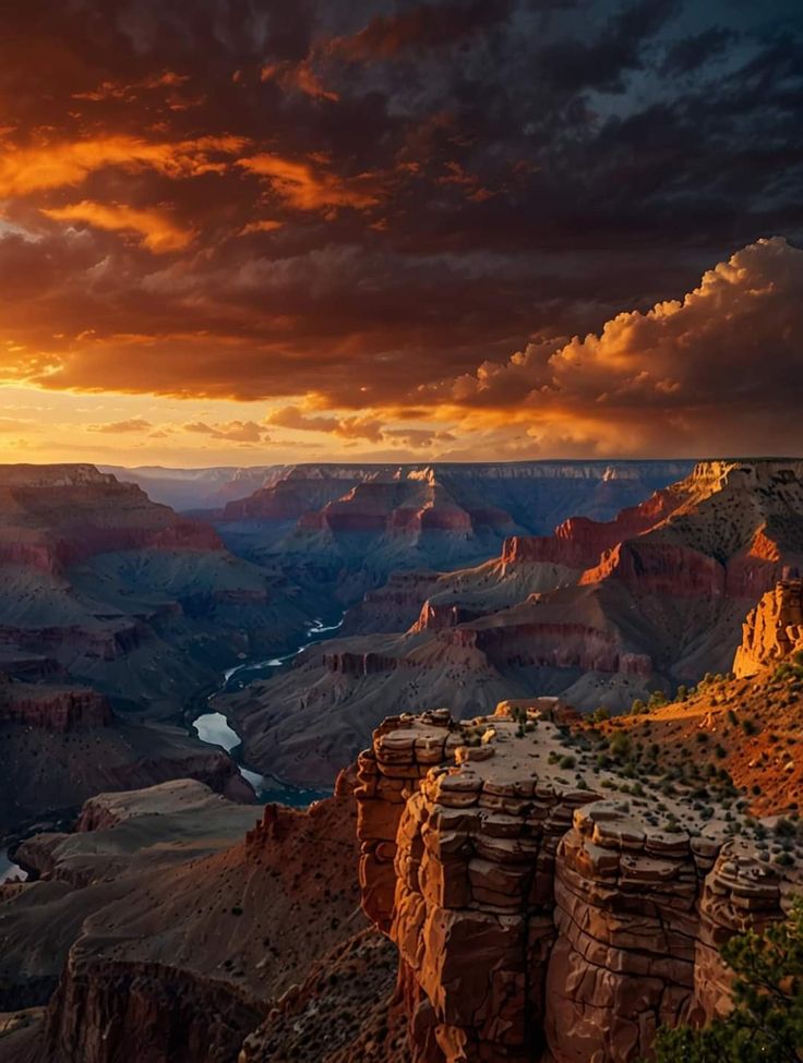 the sun is setting at the edge of the grand canyon, with clouds in the sky