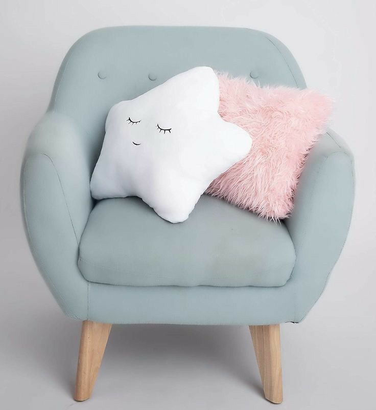 a blue chair with a pink pillow and a white star shaped pillow on it's back