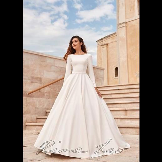 a woman in a white wedding dress standing on steps