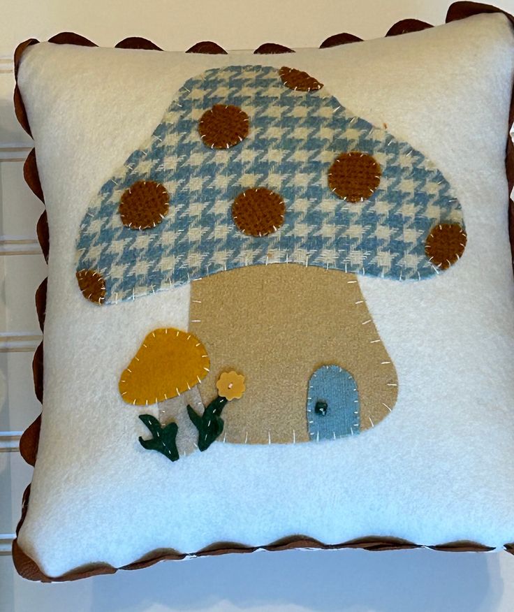 a decorative pillow with an image of a mushroom on the front, and flowers in the back