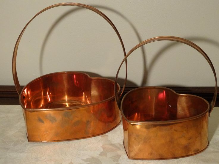 two metal baskets sitting on top of a table