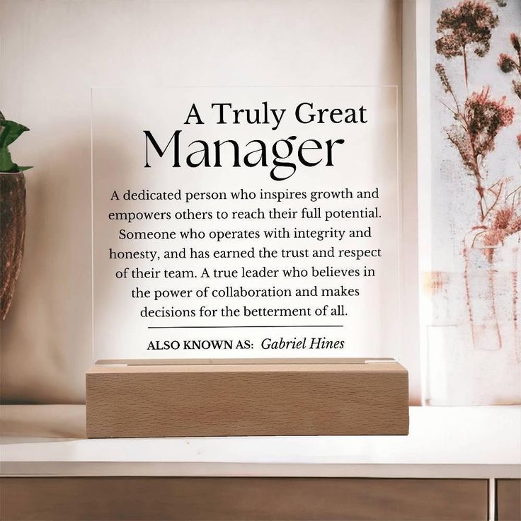 there is a quote on the shelf next to a vase with flowers in it that reads, a truly great manager