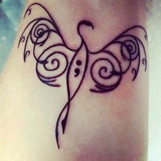 a tattoo on the leg of a woman with swirls and a bird in it