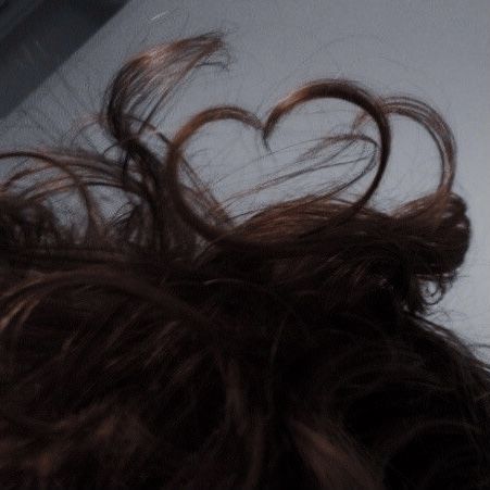 the back of a woman's head with her hair blowing in the wind, taken from above