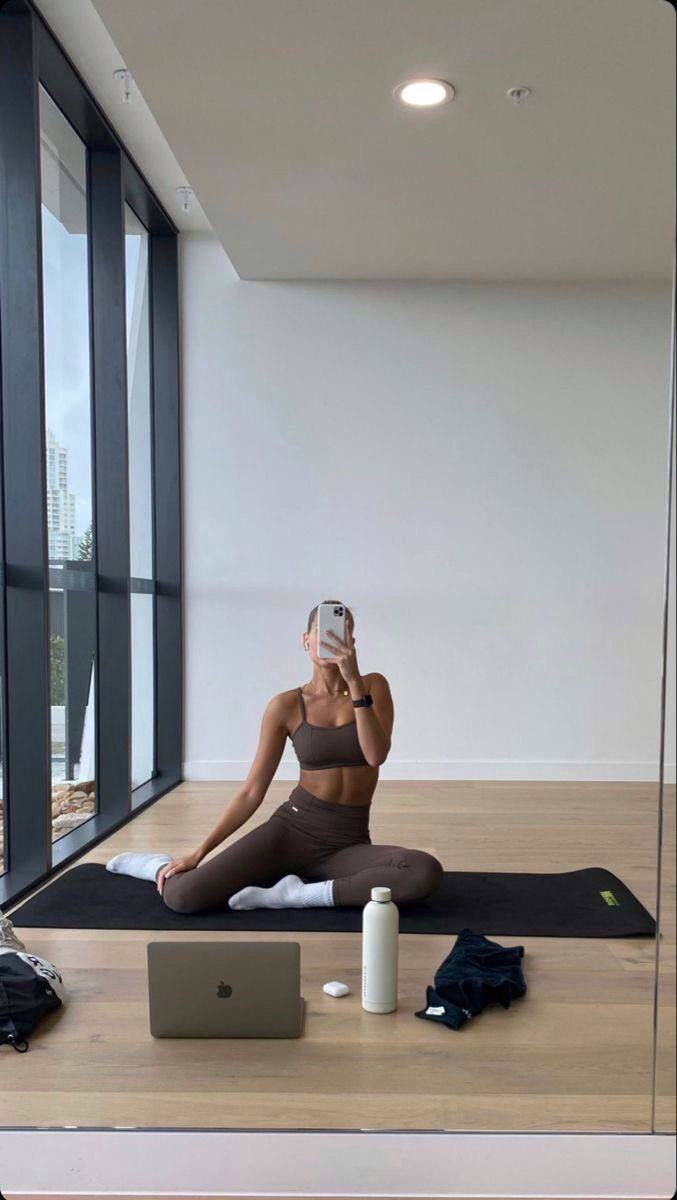 a woman sitting on the floor taking a selfie