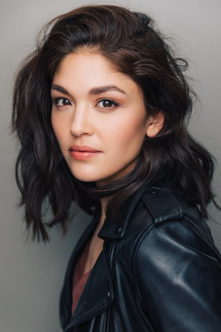 a woman in a leather jacket posing for a photo