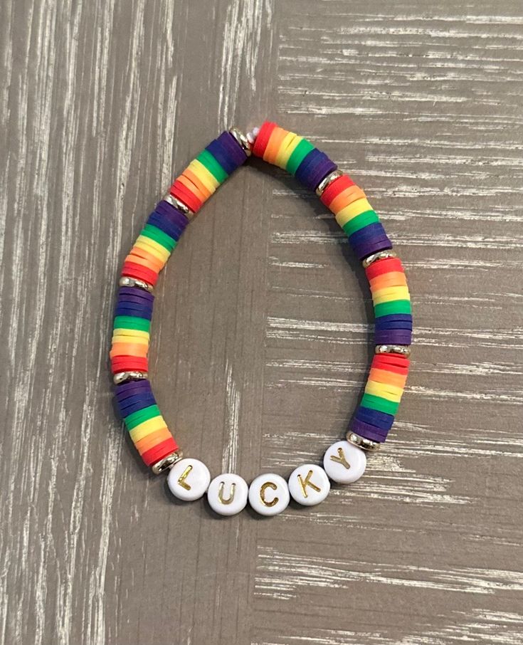 ☘️🌈☘️🌈 Get ready for St Patrick's Day with this cute rainbow and gold LUCKY bead bracelet! 🌈☘️🌈☘️ Can also be customized with your own word or name of your choice.  ☘️ Colored beads are 6 mm heishi beads 🌈The gold discs are 14k gold plated beads  ☘️Letters are all capitalized, letter beads are white with gold   🌈 Bracelets are tied with a secure knot  ☘️Strong elastic band is used in white  🌈🌈IMPORTANT- Measure your wrist prior to ordering with a flexible measuring tape or measure with a string and then measure string with ruler or tape measure. As I do not accept returns or exchanges. If your size is not listed please tell me your size in the personalization section of your order. ⭐️⭐️ 🌈To order select your size in the drop down menu.  ☘️If you would like to change the word LUCKY Colorful Heishi Beads Jewelry With Letter Beads, Rainbow Heart Beads Bracelet, Rainbow Jewelry With Letter Beads For Gift, Rainbow Colored Jewelry With Letter Beads For Gift, Rainbow Heishi Beads Bracelets As Gift, Rainbow Heishi Beads Bracelets With Spacer Beads, Rainbow Heishi Beads Bracelet As Gift, Hypoallergenic Rainbow Bracelets With Round Beads, Hypoallergenic Rainbow Beaded Bracelets