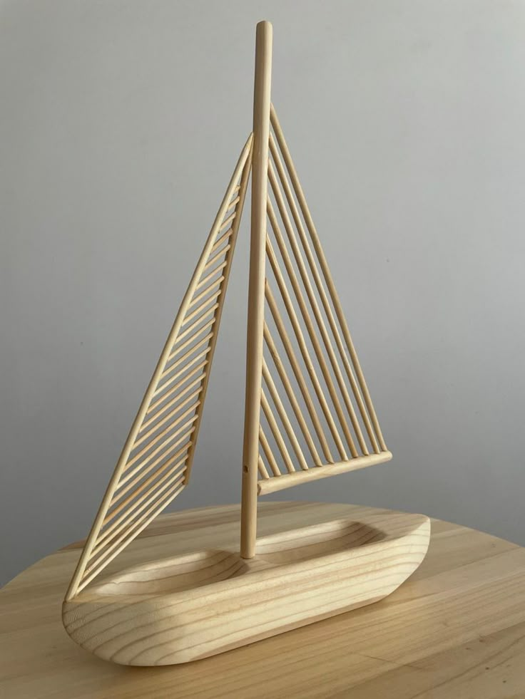 a small wooden sailboat sitting on top of a table