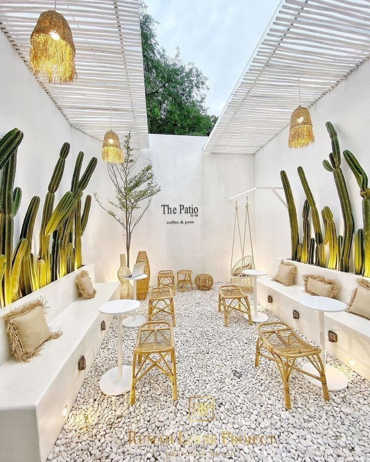 the patio is decorated in white and gold with cactus plants on the wall behind it