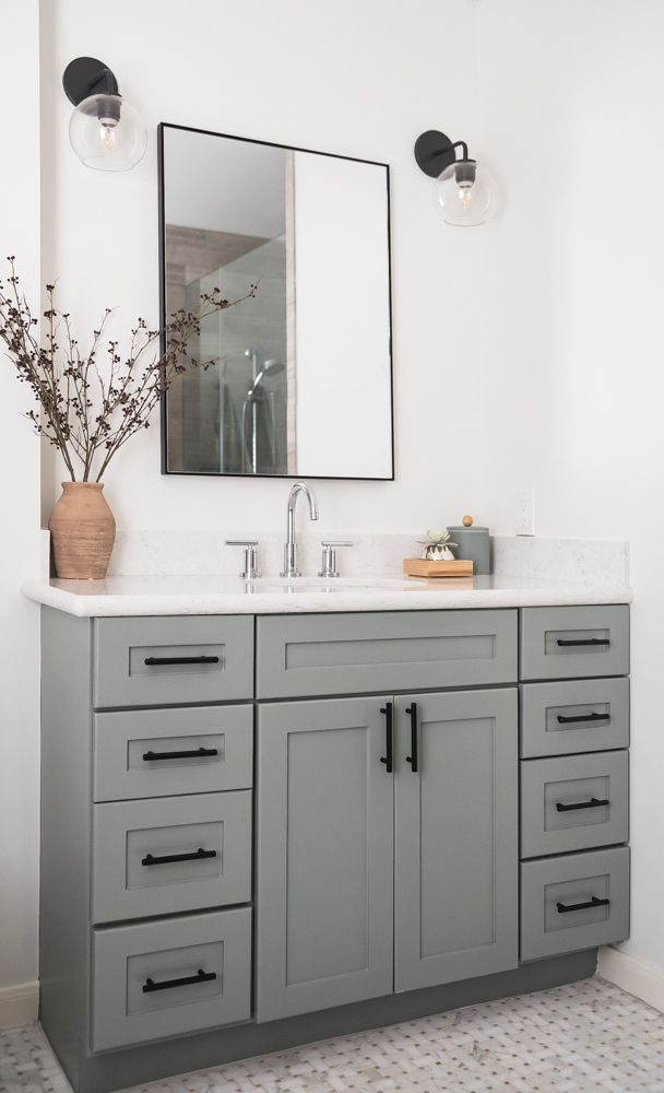 a bathroom vanity with two sinks and a large mirror