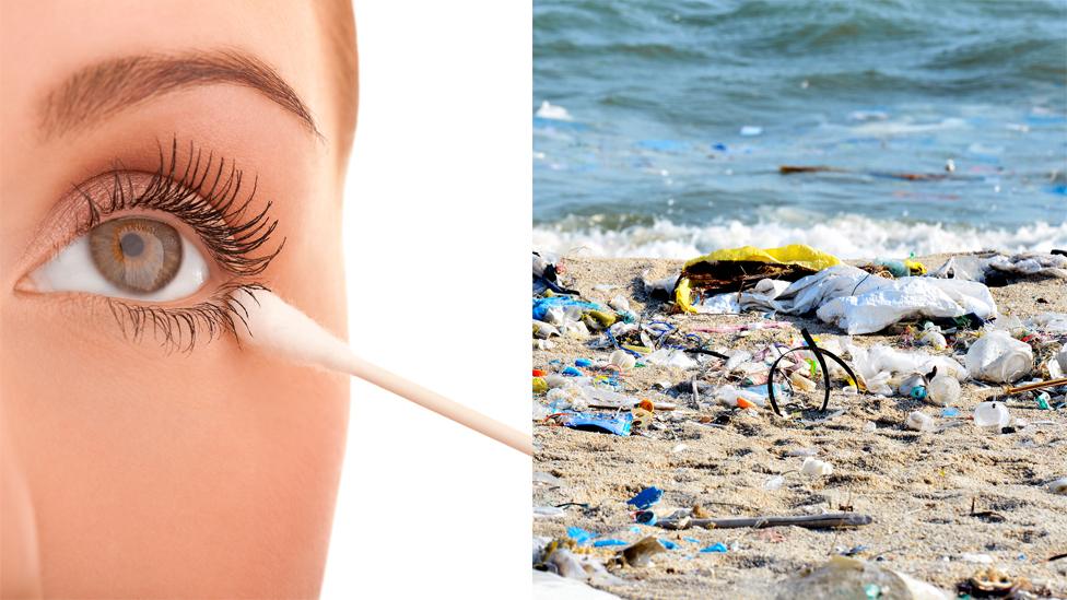 A woman with a cotton bud and some plastic on a beach