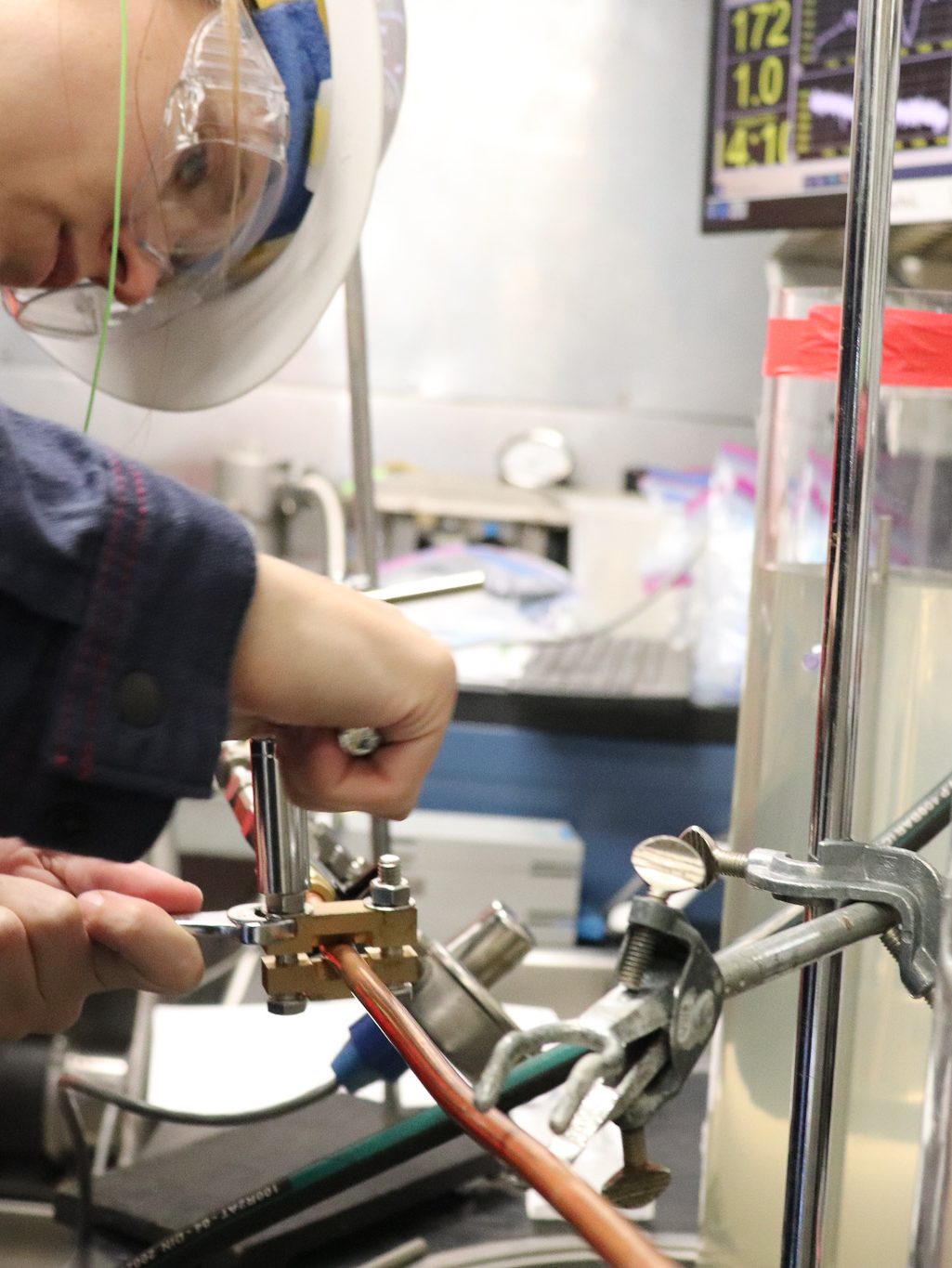 Close up of a scientists in a lab working on metal pipes and tubes