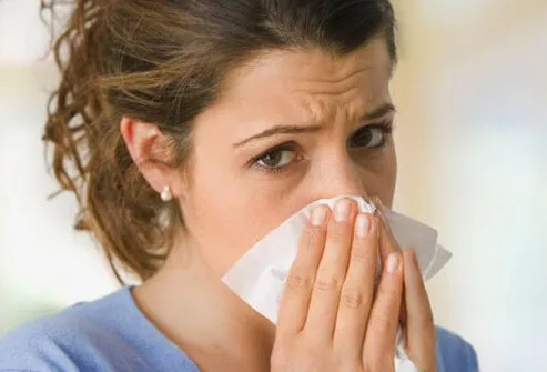 A woman blowing her nose.