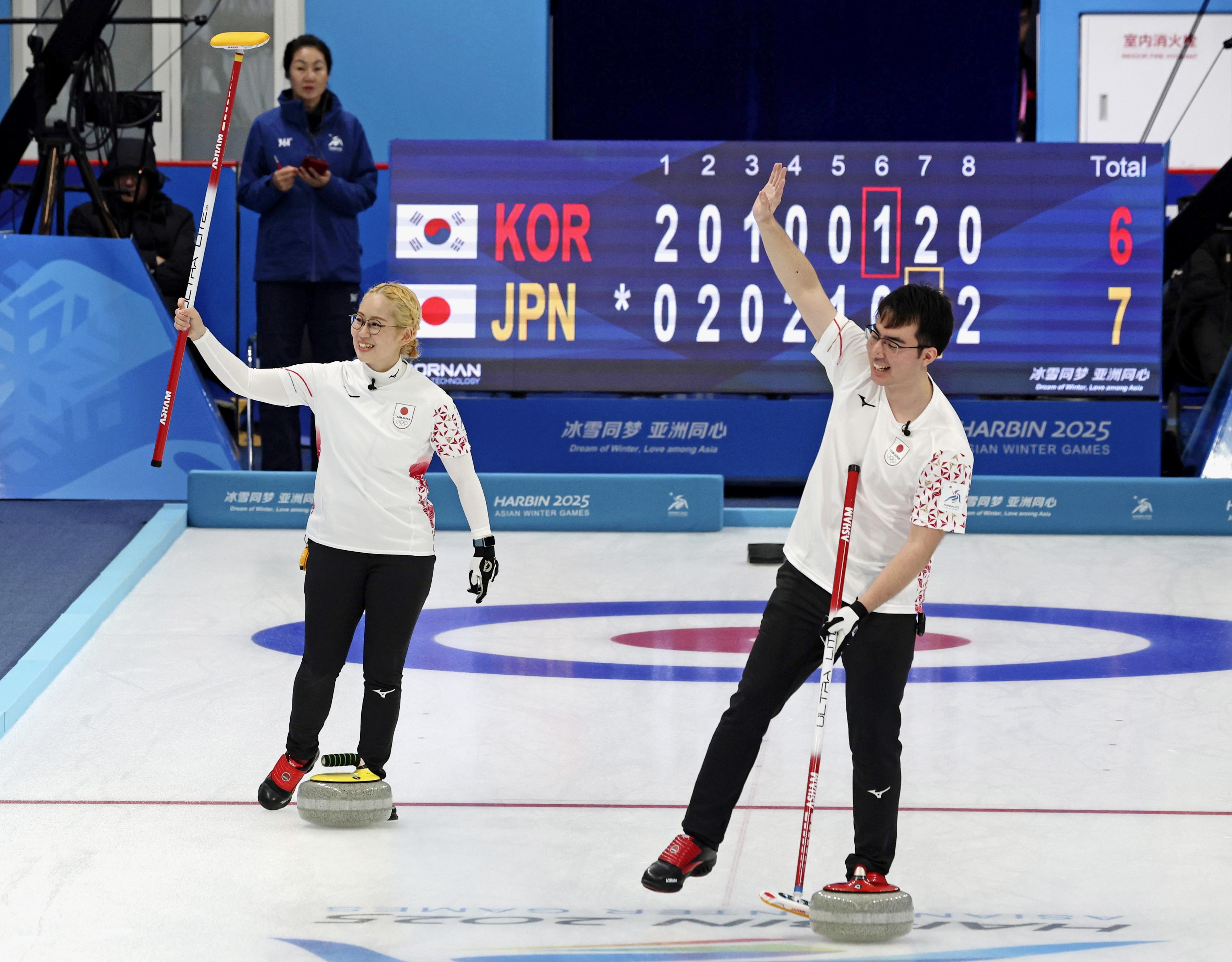 カーリング混合ダブルス決勝で韓国を破り、日本選手団の今大会金メダル第1号に輝いた小穴（左）、青木豪組＝ハルビン（共同）