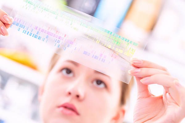 Young woman examines a spectroscopy image to analyze metal composition