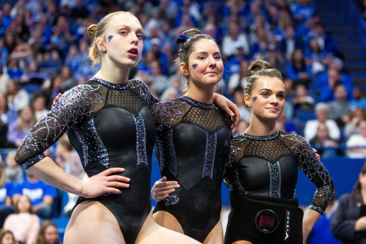 Jillian Procasky, Annie Riegert, and Makenzie Wilson watch their teammates perform during the No. 6 Kentucky vs No 5. Florida gymnastics meet on Sunday, March 3, 2024 at Rupp Arena in Lexington, Kentucky. Kentucky lost 198.100-198.225.