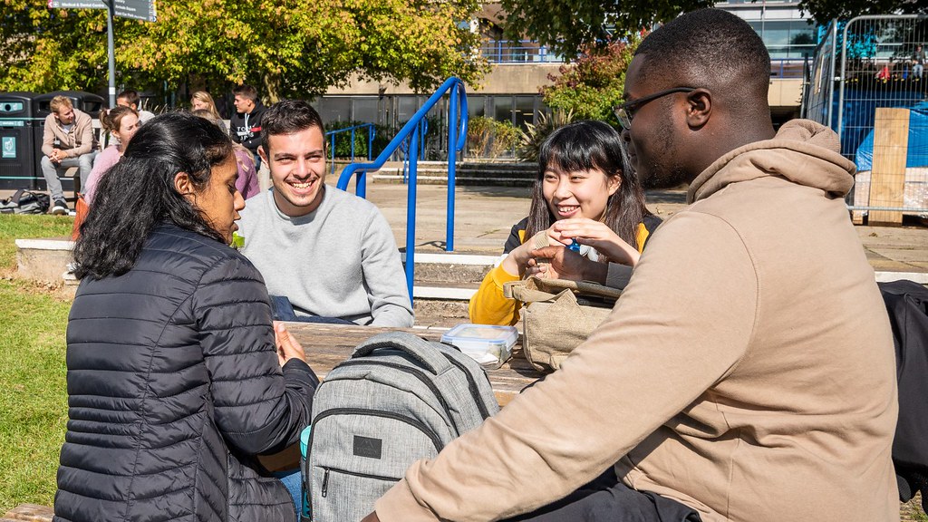 Three students smiling on campus.