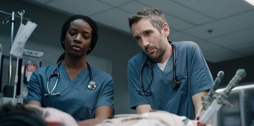 Gord Rand and Ayisha Issa in Transplant (2020)