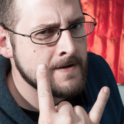 Portrait photo of Chuck, against a red textured background.