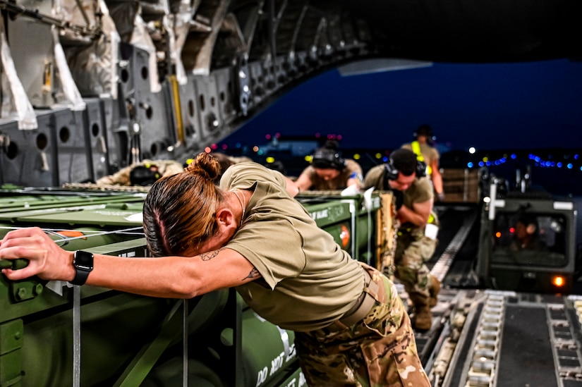 Airmen load cargo onto an aircraft.