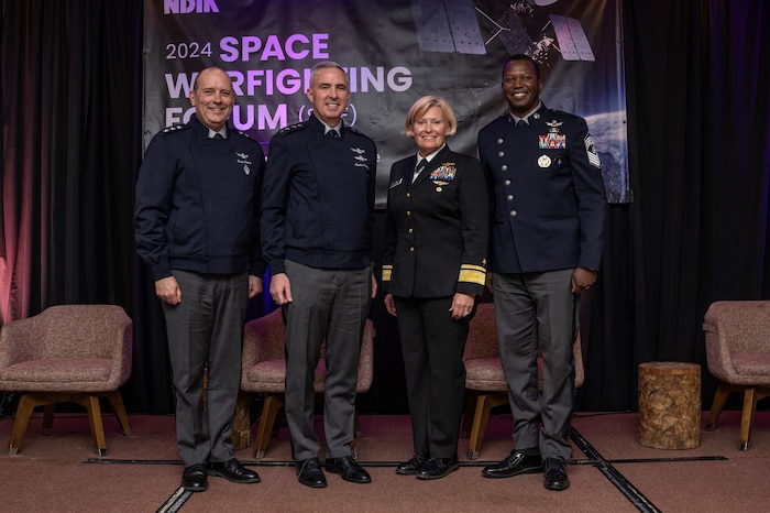 Four senior military officers pose while at a forum.