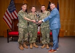 Vice Adm. Richard Correll, deputy commander of U.S. Strategic Command (USSTRATCOM), left, and Randy Norwood, assistant vice president of Military Affairs and Strategic Partnerships for the Omaha Chamber, right, present Cmdr. Jason Perris, middle left, and Cmdr. Jason Chuma, both commanding officers of the Ohio-class ballistic-missile submarine USS Kentucky (SSBN 737), with the Omaha Trophy during a presentation ceremony, Dec. 2, 2024.