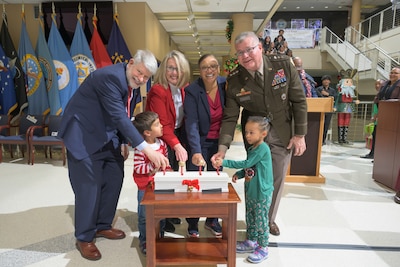 eft to right, Defense Technical Information Center Administrator Christopher Thomas; Defense Threat Reduction Agency Director of Acquisition, Contracts and Logistics Directorate Teresa Kless; Defense Contract Audit Agency Deputy Director Debra Caw; and Defense Logistics Agency Director Army Lt. Gen. Mark Simerly, , light the holiday tree during a ceremony accompanied by two preschool students from the McNamara Headquarters Complex Child Development Center